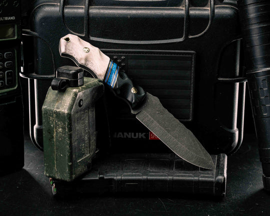 Disaster Jr- Black Canvas Micarta, Black G10, Brass, Blue G10 and White G10 Pin Striping, Dark Denim Lapis Recon Stone Split, Elk Antler, Brass Mosaic Pins, Brass Lanyard Pin, Textured Grip