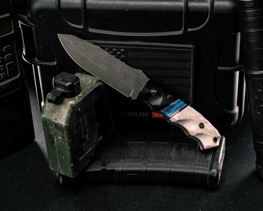 Disaster Jr- Black Canvas Micarta, Black G10, Brass, Blue G10 and White G10 Pin Striping, Dark Denim Lapis Recon Stone Split, Elk Antler, Brass Mosaic Pins, Brass Lanyard Pin, Textured Grip
